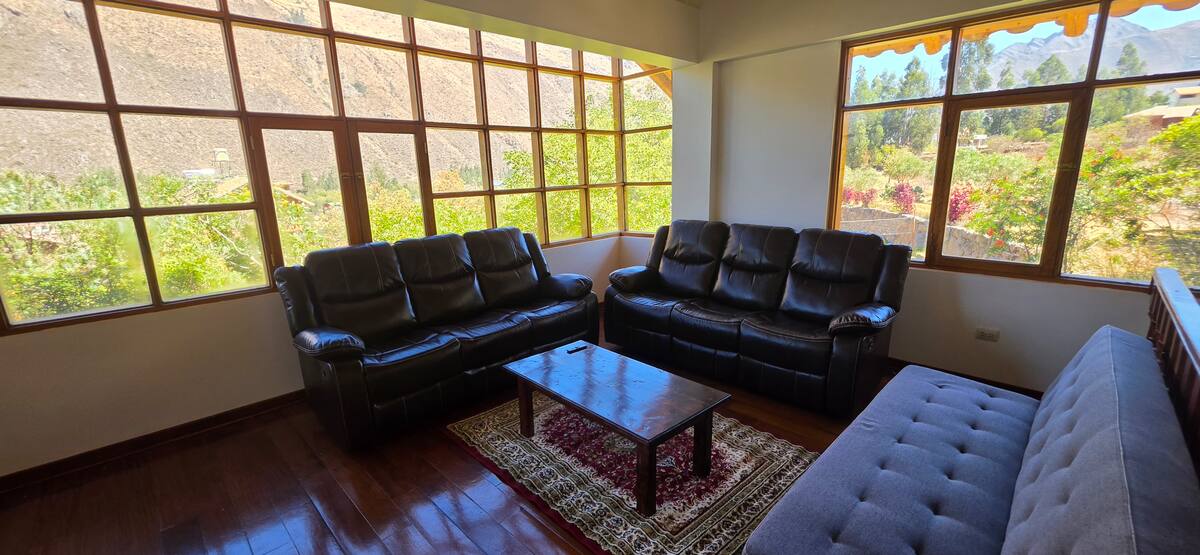 Sala de estar con sofás y vista abierta al Valle Sagrado