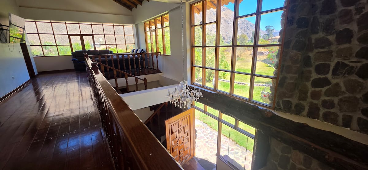 Escalera interior con baranda de madera y vista al valle
