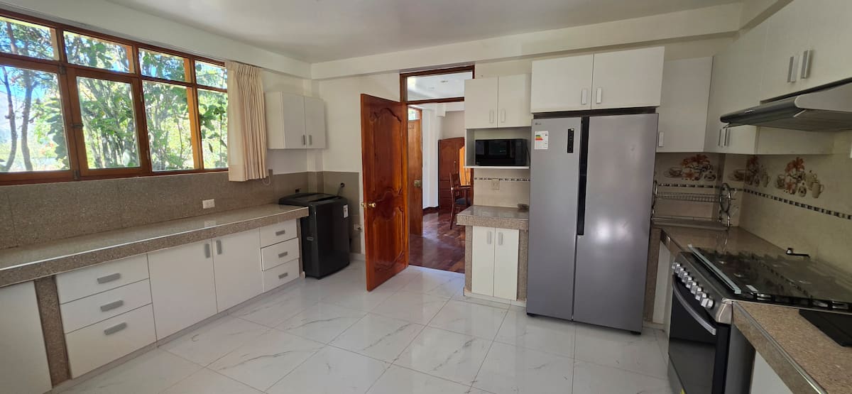 Cocina blanca equipada con refrigerador de dos puertas