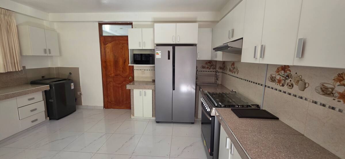 Zona de cocina con horno, estufa y utensilios listos