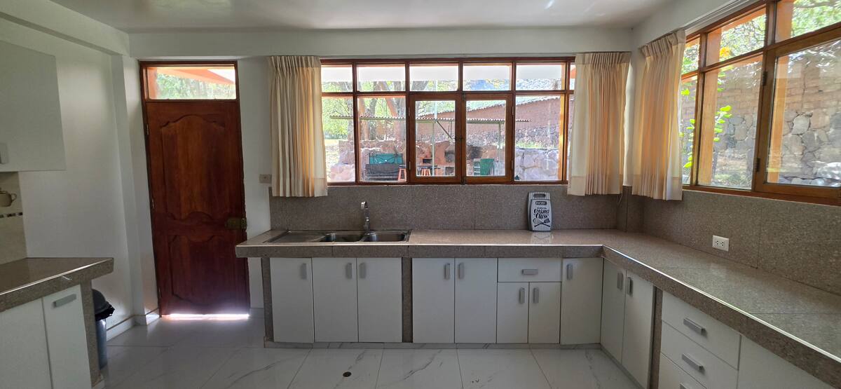 Cocina con ventanales y vista al jardín de la propiedad