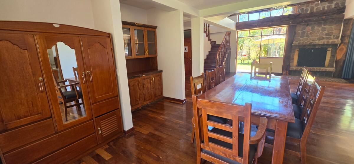 Comedor con mesa de madera maciza junto a la escalera principal