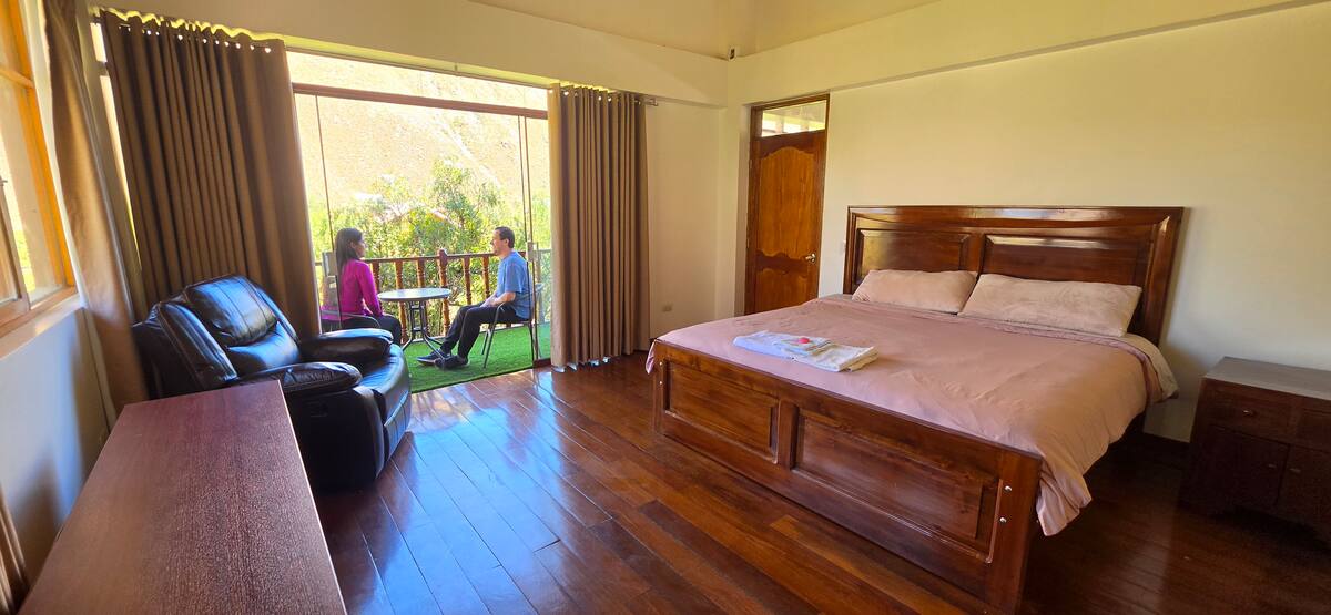 Habitación con cama king y rincón de lectura junto a la ventana