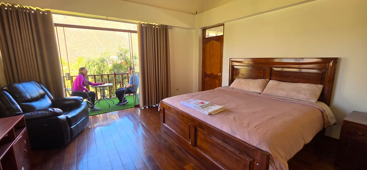Habitación con cama king y vista al jardín y las montañas