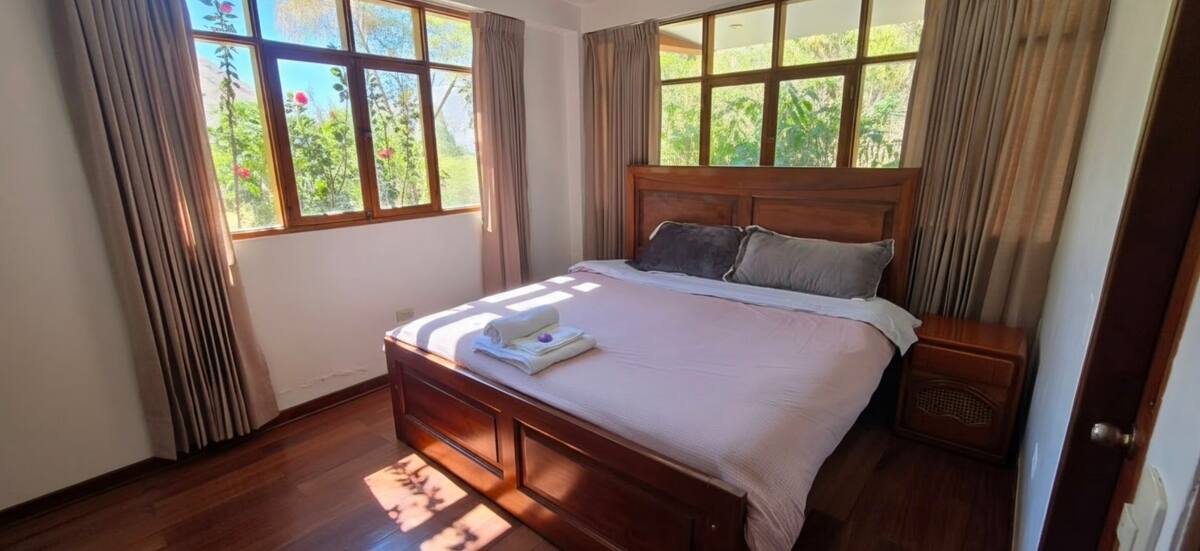 Habitación con cama king, sofá y ventana con vista al exterior
