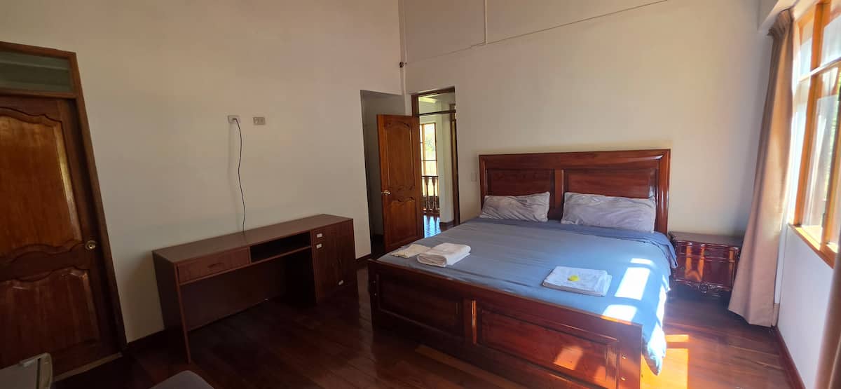 Habitación con cama king y escritorio junto a la ventana