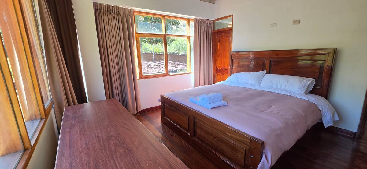 Habitación con cama king y ventana con vista al Valle Sagrado