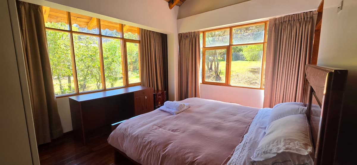 Habitación con cama king y detalles cálidos en madera