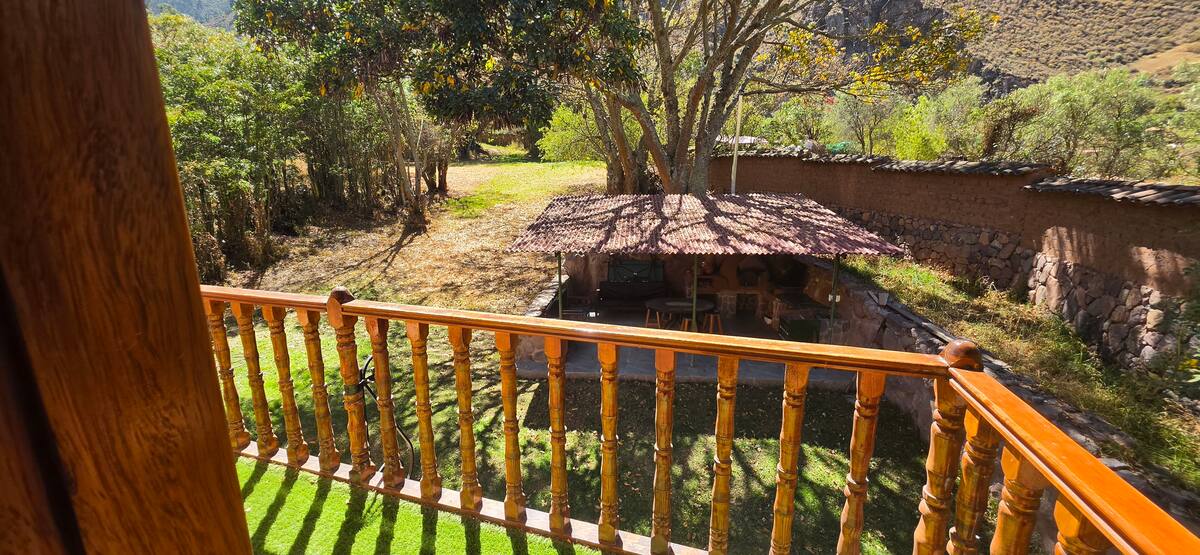Segundo balcón rodeado de árboles con vista al jardín