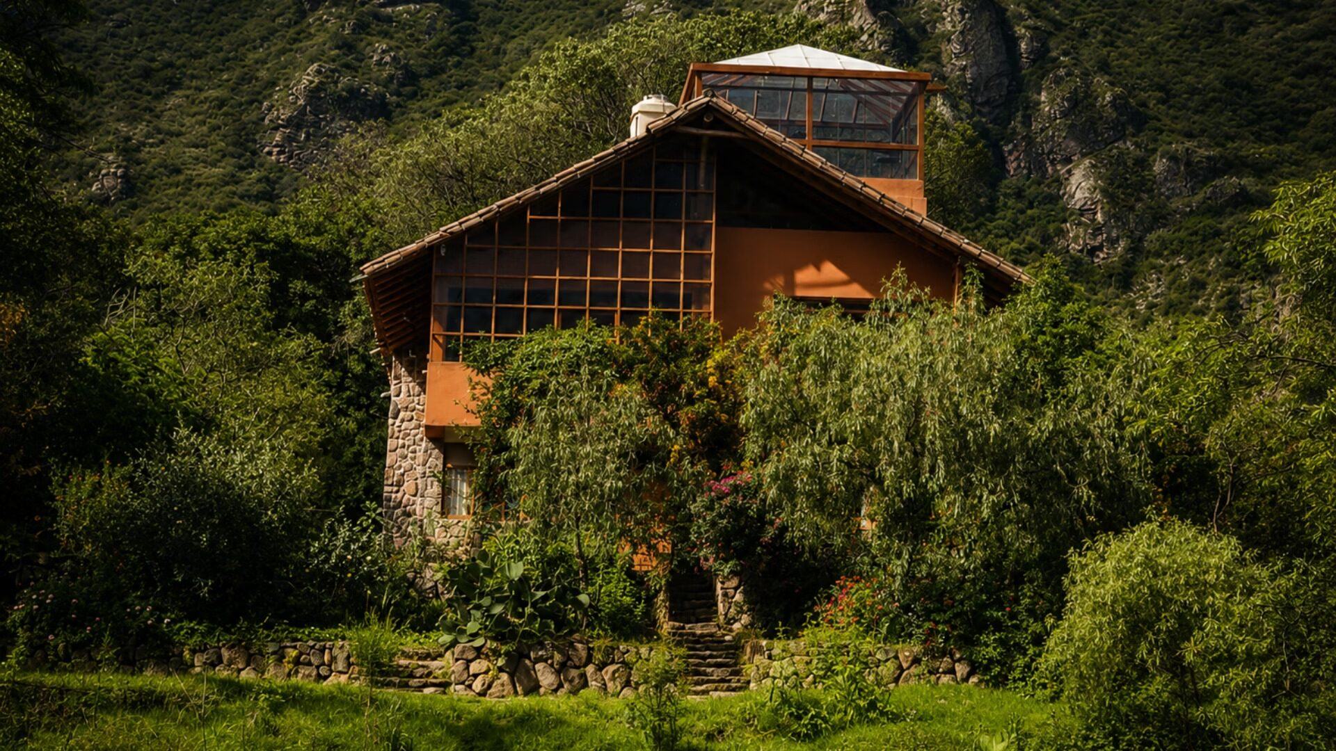 Vista de la casa enmarcada por sauces y árboles nativos