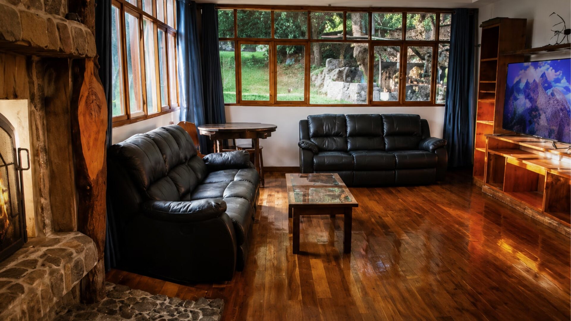 Sala de estar con sofás de cuero y ventanal hacia el jardín